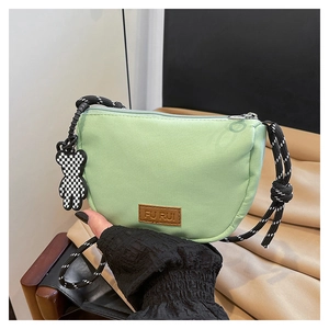 Dettaglio della borsa a tracolla a mezzaluna verde chiaro in nylon con tracolla intrecciata