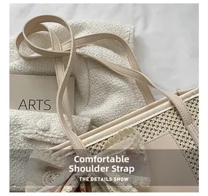 Detail view of cream straw tote bag featuring leather shoulder strap and lace floral trim