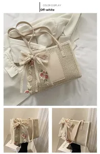 Detail of beige straw tote bag featuring floral lace bow and woven texture detail