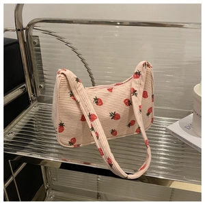 Détail du sac à bandoulière en velours côtelé rose avec imprimé fraise et fermeture