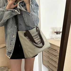 Grand sac cabas gris-vert avec poignées marron et bandoulière réglable pour le porté épaule
