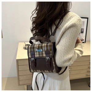 Detail of retro plaid mini backpack with dog embroidery and brown leather buckles