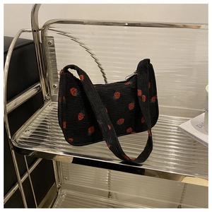 Détail du sac à bandoulière en velours côtelé noir avec imprimé fraise et zip argenté