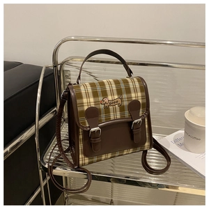 Detail of British vintage plaid handbag featuring dachshund embroidery and leather strap