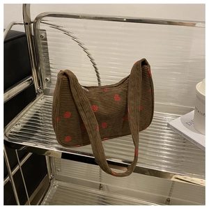 Détail du sac à bandoulière en velours côtelé marron avec imprimé fraise rouge