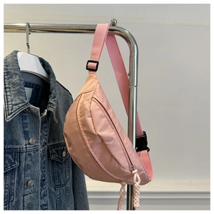 Detail of pink nylon waist bag showing adjustable strap, plastic buckle and woven zip puller