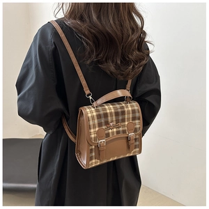 Detail of brown plaid backpack with dachshund embroidery and adjustable leather straps