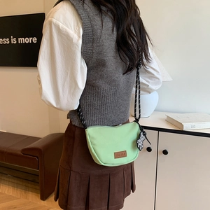 Borsa a tracolla in nylon verde menta con tracolla intrecciata e logo in pelle