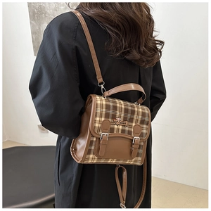 Rear view of model wearing a vintage brown plaid backpack with dog embroidery detail