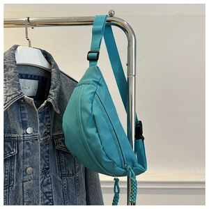 Detail of turquoise nylon waist bag with smooth curved zipper and adjustable strap