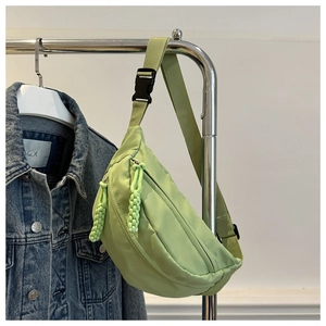 Detail of lime green nylon crescent chest bag with woven pulls and adjustable buckle
