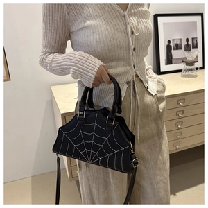 Detail of black PU leather handbag featuring white spider web contrast stitching pattern