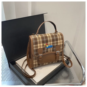 Detail of checkered canvas backpack with dachshund embroidery on luxury gift box packaging