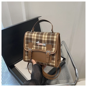 Detail showing vintage brown plaid fabric and a delicate puppy embroidery on the bag