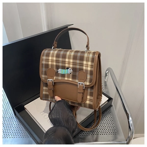 Detail of retro plaid backpack featuring dachshund embroidery and brown leather trim