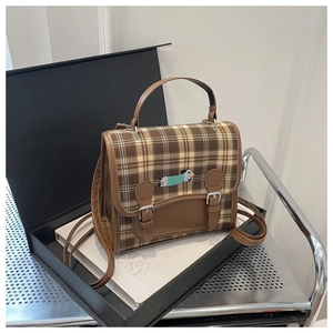 Detail shot of vintage plaid backpack with dachshund embroidery on a premium gift box