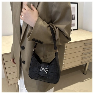 Dettaglio borsa hobo nera in ecopelle con motivo coccodrillo e fibbia a fiocco argento