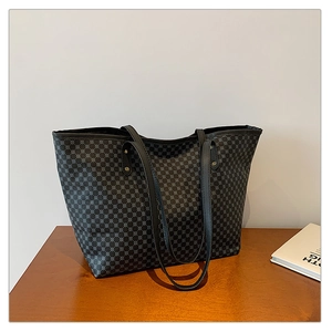 Close-up of the black tote bag with gray geometric dot texture on a wooden surface