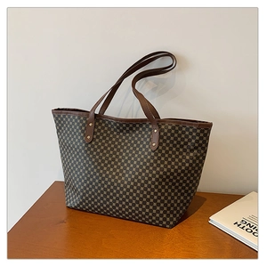 Detail view of large brown tote bag with geometric dotted pattern and leather handles
