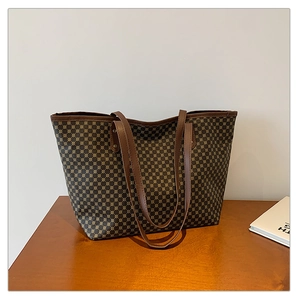 Close-up of deep brown tote bag with light brown geometric pattern on wooden desk