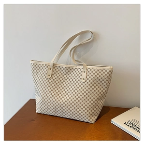 Detailed view of large tote bag with brown geometric diamond pattern and slim straps
