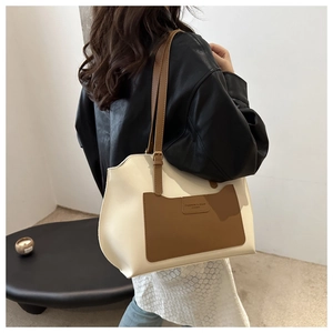 Détail du sac cabas minimaliste crème et marron avec bandoulière et texture de poche