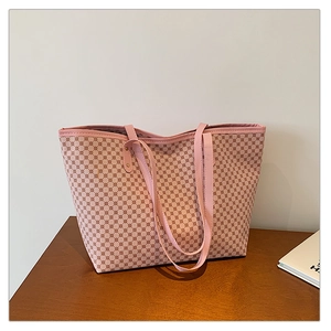 Detailed view of the pink tote bag featuring vintage geometric patterns on a wooden surface