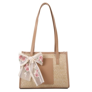 Elegant straw tote bag with leather handles and a floral lace ribbon for beach summer