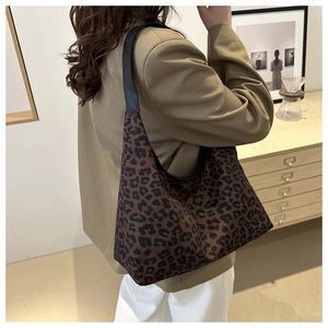 Détail du grand sac cabas à imprimé léopard avec bandoulière en cuir noir sur un mannequin