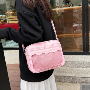 Borsa a tracolla rosa alla moda con bordi ondulati e tasca a rete indossata da modella