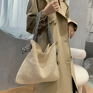 Minimalist straw woven tote bag with houndstooth ribbon handles for beach vacations