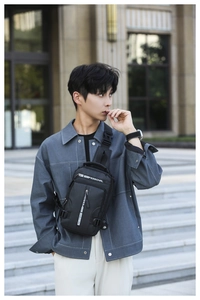 Detail of black waterproof men's crossbody bag with stylish white strap and zippers