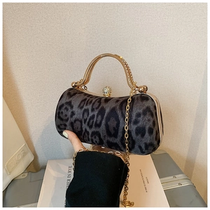Detail of leopard print evening clutch with rhinestone clasp and gold metal handle