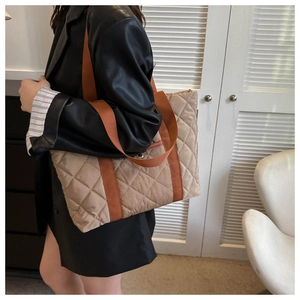 Quilted nylon tote bag in khaki and orange shown being worn in a stylish interior