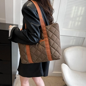 Grand sac cabas matelassé marron café avec bandoulière orange porté par un mannequin