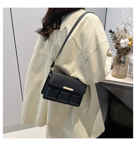 Detailed view of black matte leather shoulder bag with unique geometric quilted texture