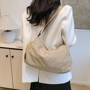 Sac bandoulière en nylon beige minimaliste avec ruban mode et fermeture éclair durable