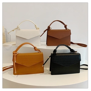 Close-up of stone pattern crossbody bags in four colors with braided handle detail