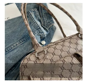 Detail of khaki monogram underarm bag featuring silver hardware and classic fabric texture