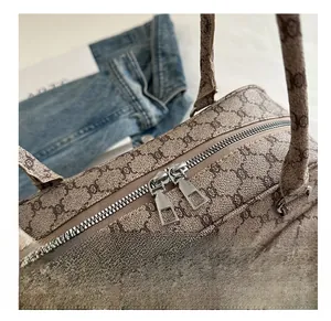 Detail view of smooth double metal zippers on a brown vintage patterned underarm bag