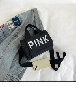 Détail du sac cylindrique noir en nylon avec lettrage PINK blanc et bandoulière
