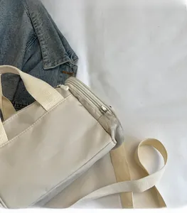 Gros plan détaillé du sac à main beige en nylon avec fermeture éclair métallique