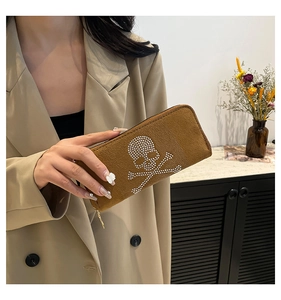 Close-up of brown suede long wallet with rhinestone skull and crossbones design