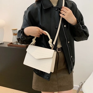 White faux crocodile skin crossbody bag with unique knot handle and gold hardware detail