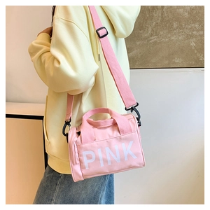 Détail du sac de sport en toile rose avec logo PINK blanc imprimé en lettres