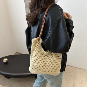 Borsa tote in maglia beige con spalline in pelle marrone indossata da una modella