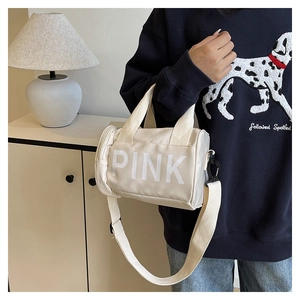 Détail d'un sac de sport cylindrique blanc avec logo PINK et bandoulière réglable