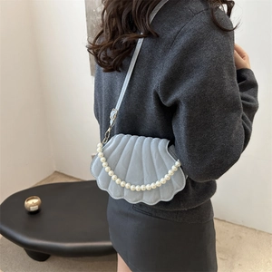 Light blue shell-shaped crossbody bag with pearl strap and refined textured surface