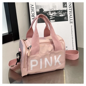 Détail du sac de sport cylindrique rose avec lettrage PINK et bandoulière en nylon robuste