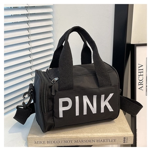 Gros plan d'un sac de sport noir avec imprimé lettres blanches et sangle en nylon